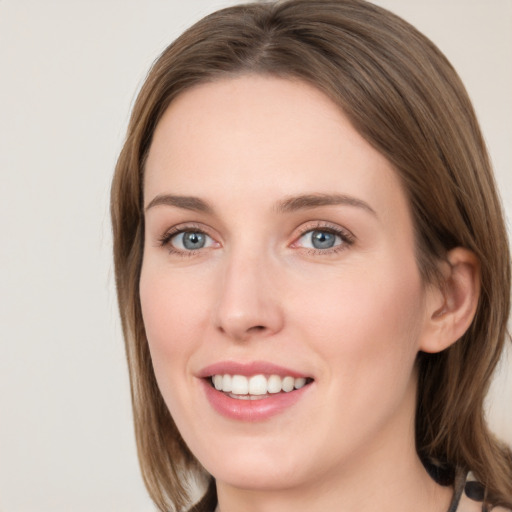 Joyful white young-adult female with long  brown hair and blue eyes