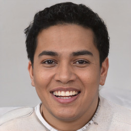 Joyful latino young-adult male with short  brown hair and brown eyes