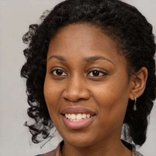 Joyful black young-adult female with medium  brown hair and brown eyes