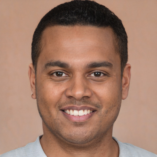Joyful latino young-adult male with short  brown hair and brown eyes