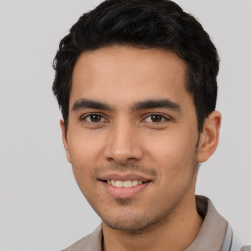 Joyful latino young-adult male with short  black hair and brown eyes