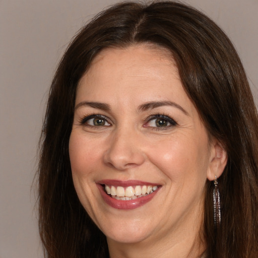 Joyful white adult female with long  brown hair and brown eyes