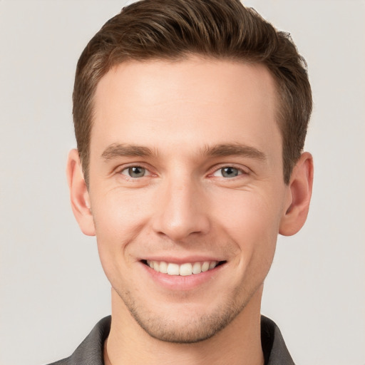 Joyful white young-adult male with short  brown hair and grey eyes