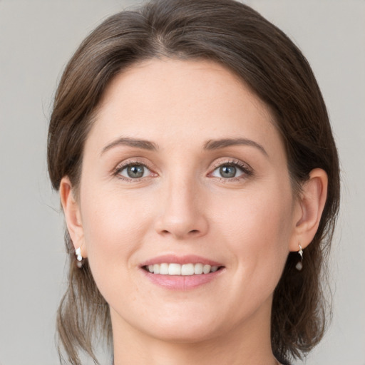 Joyful white young-adult female with medium  brown hair and grey eyes