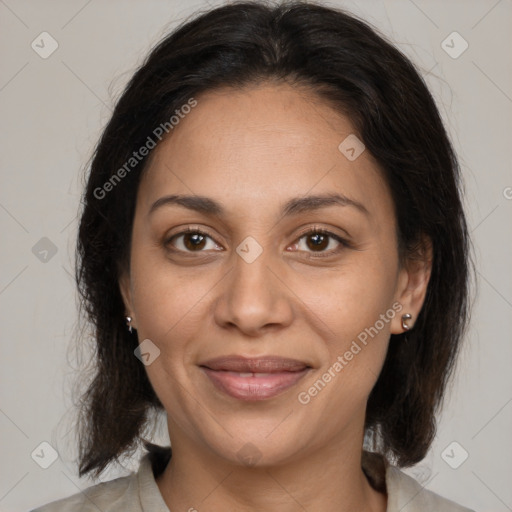 Joyful latino adult female with medium  brown hair and brown eyes