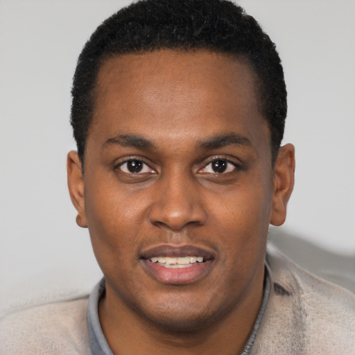 Joyful black young-adult male with short  black hair and brown eyes