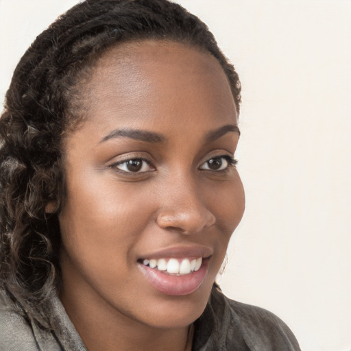 Joyful black young-adult female with long  brown hair and brown eyes