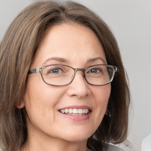 Joyful white adult female with medium  brown hair and grey eyes