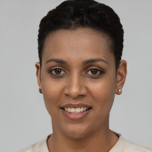 Joyful black young-adult female with short  black hair and brown eyes