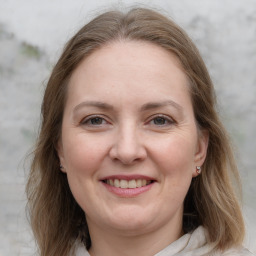 Joyful white adult female with long  brown hair and grey eyes