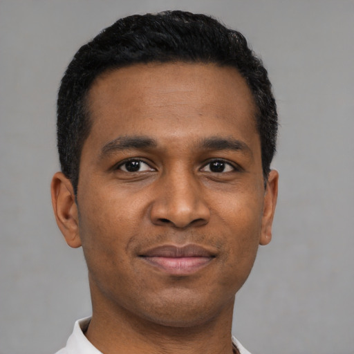 Joyful latino young-adult male with short  black hair and brown eyes