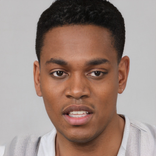 Joyful black young-adult male with short  black hair and brown eyes