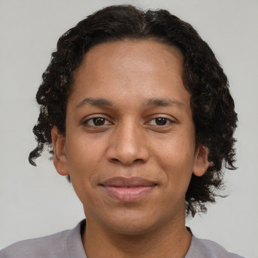 Joyful black adult female with short  brown hair and brown eyes