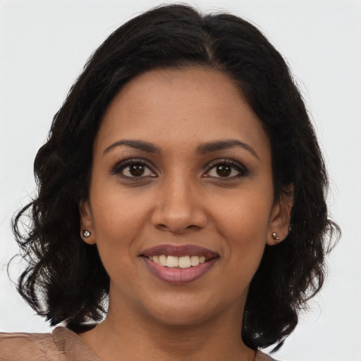 Joyful black young-adult female with long  brown hair and brown eyes
