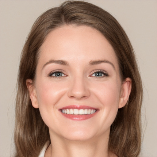 Joyful white young-adult female with medium  brown hair and grey eyes