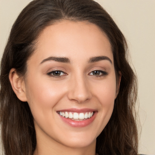 Joyful white young-adult female with long  brown hair and brown eyes