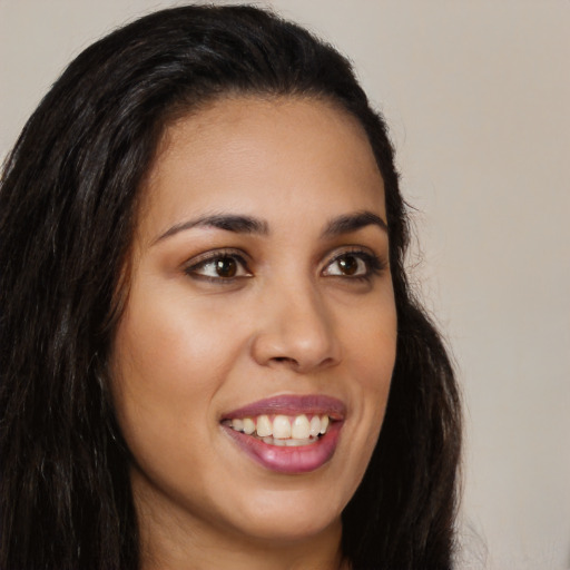 Joyful latino young-adult female with long  brown hair and brown eyes