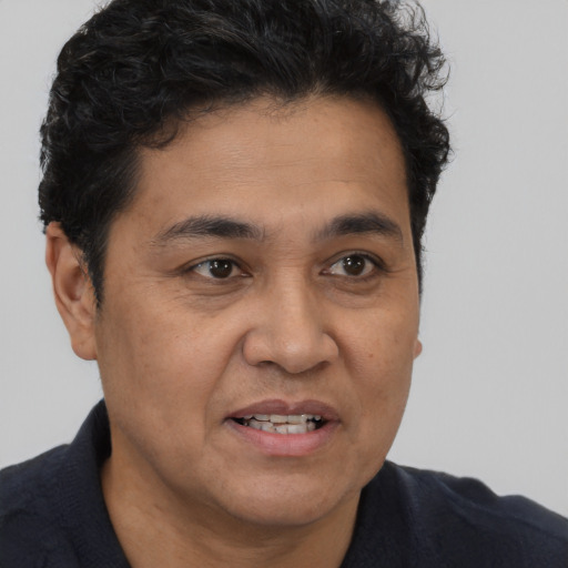 Joyful latino adult male with short  brown hair and brown eyes