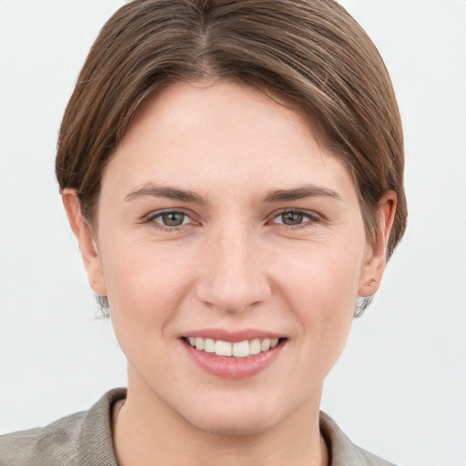 Joyful white young-adult female with short  brown hair and grey eyes