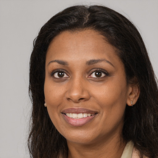 Joyful black adult female with long  brown hair and brown eyes
