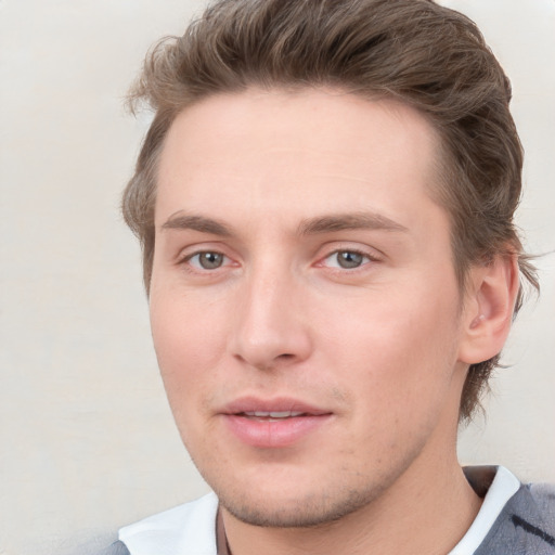 Joyful white young-adult male with short  brown hair and blue eyes