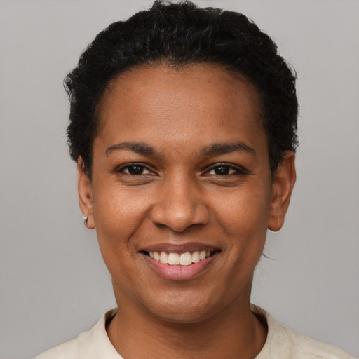 Joyful black young-adult female with short  black hair and brown eyes