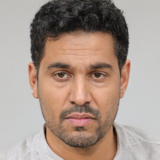 Joyful latino adult male with short  black hair and brown eyes