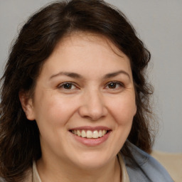 Joyful white adult female with medium  brown hair and brown eyes