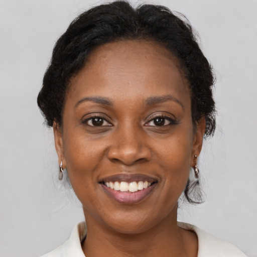 Joyful black adult female with medium  brown hair and brown eyes