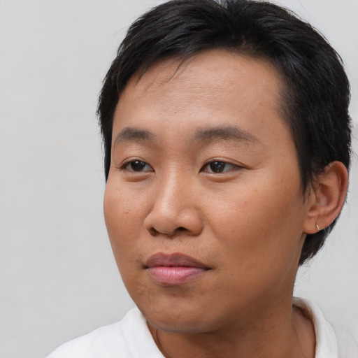 Joyful asian young-adult male with short  black hair and brown eyes