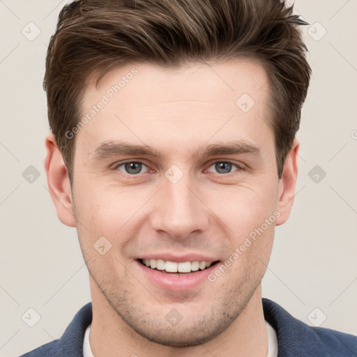 Joyful white young-adult male with short  brown hair and grey eyes