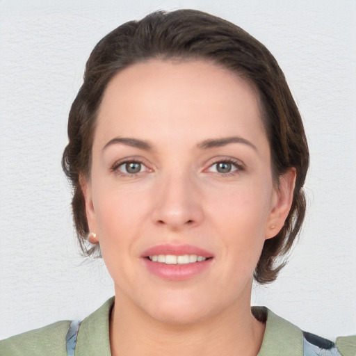 Joyful white young-adult female with short  brown hair and grey eyes