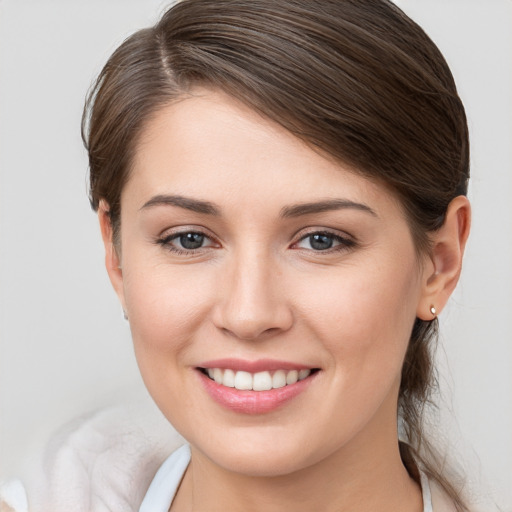 Joyful white young-adult female with medium  brown hair and grey eyes