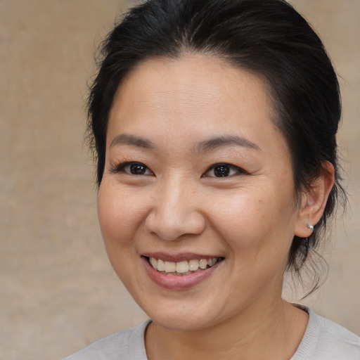 Joyful asian young-adult female with medium  brown hair and brown eyes