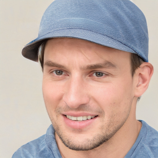 Joyful white young-adult male with short  brown hair and blue eyes