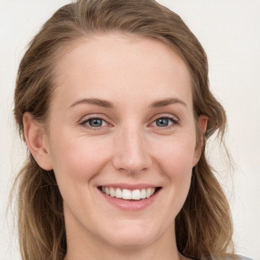 Joyful white young-adult female with long  brown hair and blue eyes