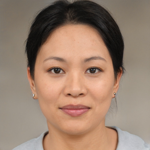 Joyful asian adult female with medium  brown hair and brown eyes