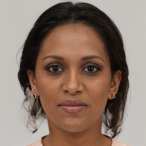 Joyful black adult female with medium  brown hair and brown eyes