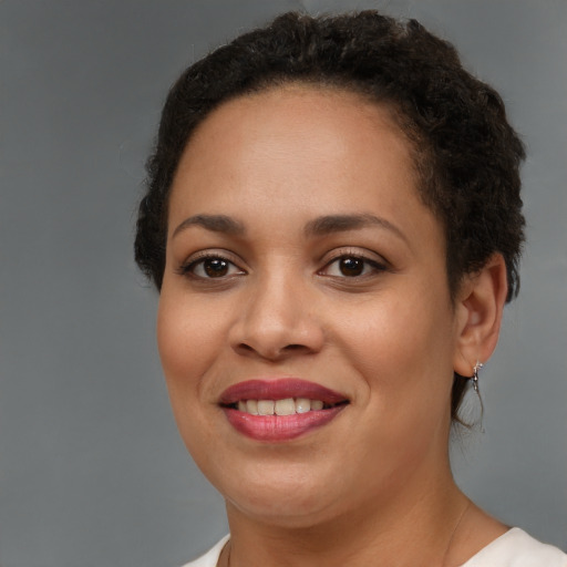 Joyful black young-adult female with short  brown hair and brown eyes