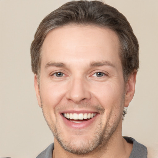 Joyful white adult male with short  brown hair and brown eyes