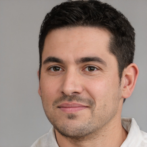 Joyful white young-adult male with short  black hair and brown eyes
