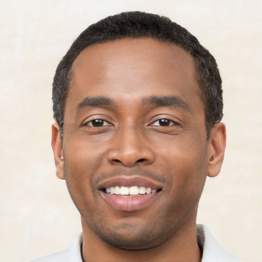 Joyful black young-adult male with short  black hair and brown eyes