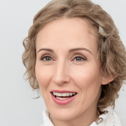 Joyful white adult female with medium  brown hair and green eyes