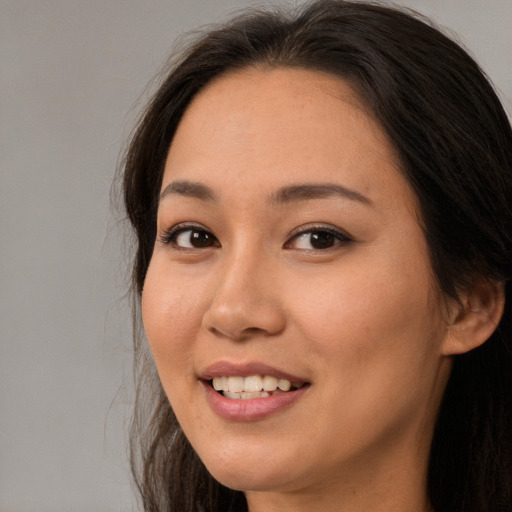 Joyful asian young-adult female with long  brown hair and brown eyes
