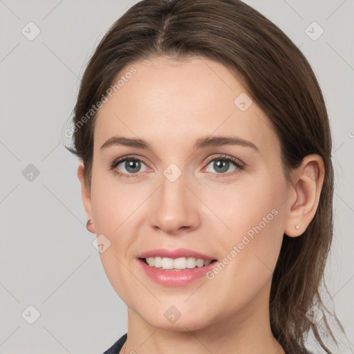 Joyful white young-adult female with medium  brown hair and grey eyes