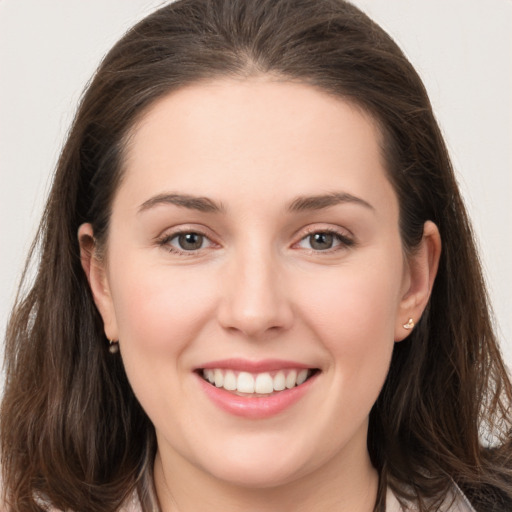 Joyful white young-adult female with long  brown hair and brown eyes