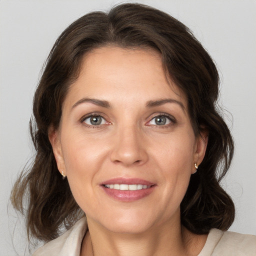 Joyful white adult female with medium  brown hair and grey eyes