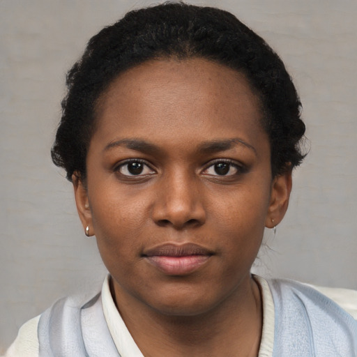 Joyful black young-adult female with short  black hair and brown eyes