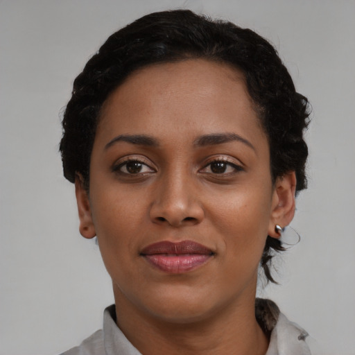 Joyful black young-adult female with short  brown hair and brown eyes