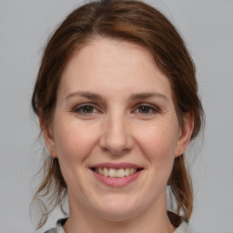 Joyful white young-adult female with medium  brown hair and grey eyes